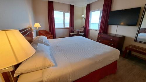 Habitación de hotel con cama y TV en Hotel Diego de Almagro Punta Arenas, en Punta Arenas