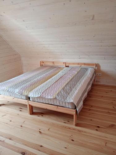 Bett in einem Zimmer mit Holzboden in der Unterkunft Domek nad Wisłą 