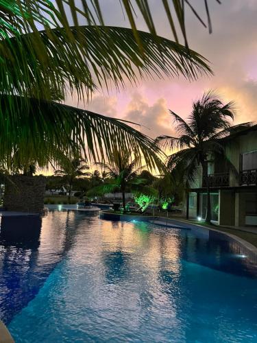 una gran piscina con palmeras frente a un edificio en Pipa Paradise Top 1, en Pipa