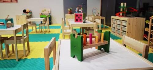 a classroom with desks and tables and a toy train at Arena Franz Ferdinand Nassfeld in Tröpolach