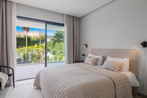 sypialnia z łóżkiem i dużym oknem w obiekcie Brand New Modern 5 BDRM Villa in Puerto Banús w Marbelli