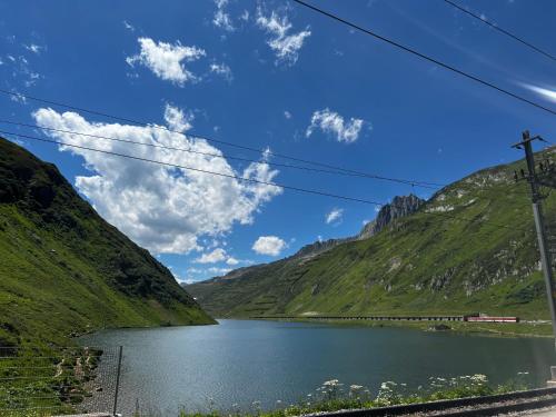 a view of a mountain lake with a train at Casa Ucliva - Charming Alpine Apartment Getaway in the Heart of the Swiss Alps in Rueras