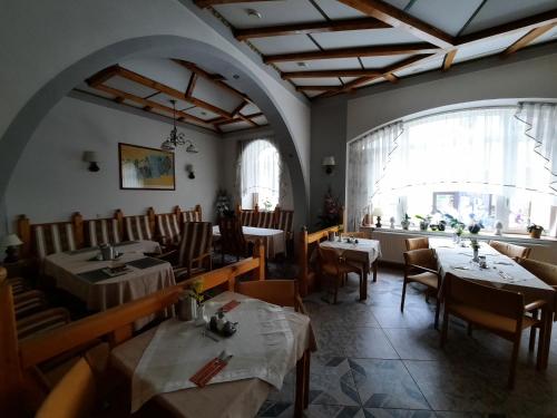 a restaurant with tables and chairs and a large window at Hotel Koruna in Jeseník
