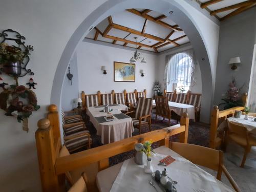 a dining room with tables and chairs and an archway at Hotel Koruna in Jeseník