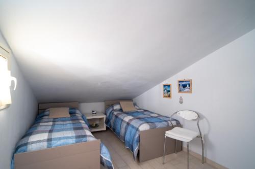 een slaapkamer met 2 bedden en een tafel bij Casa Vacanza Giugiò in Giardini Naxos