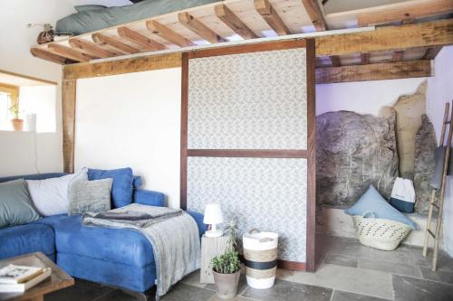 a living room with a blue couch and a wall at Eco lodge Carbonaccio in Chiatra