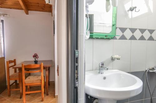 a bathroom with a sink and a table with a chair at Guest House Gerard in Ksamil