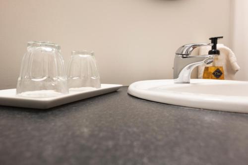 a bathroom with a sink and two glasses on a counter at Hótel Fljótshlíd in Hlíðarendi
