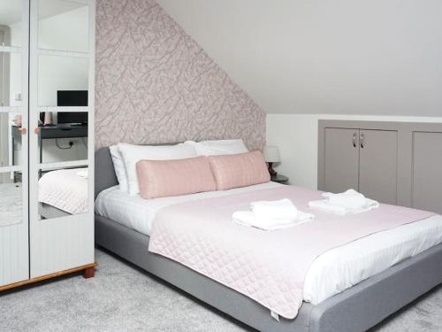 a bedroom with a large white bed with pink pillows at Horizon House, Modern Studio Flat, Parking Space, Oxford in Oxford