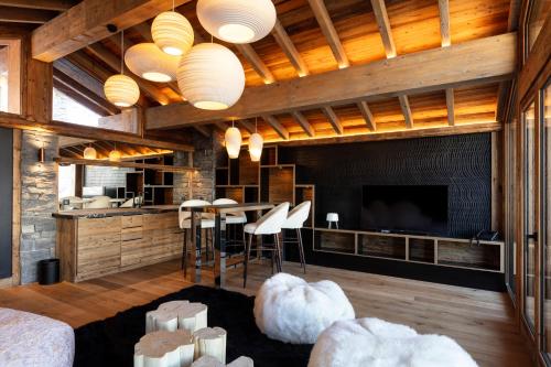 a living room with a large television and a couch at M Lodge & Spa in Saint-Martin-de-Belleville