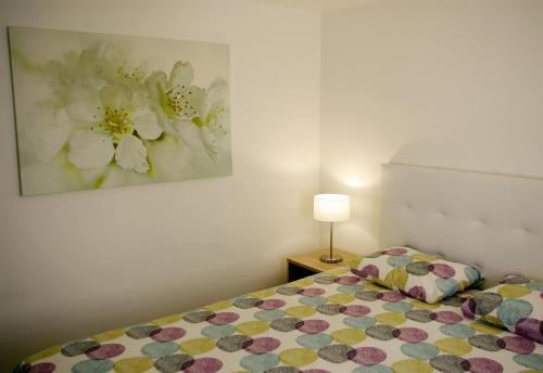 een slaapkamer met een bed met een bloemschilderij aan de muur bij Fabulous upper floor sea view in San Agustin