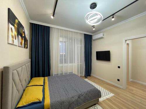 a bedroom with a bed and a television in it at Апартаменты Soul Park in Astana