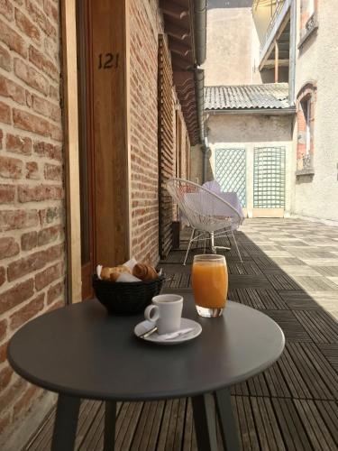 een tafel met een kopje koffie en een glas sinaasappelsap bij The Originals Boutique, Grand Hôtel Saint-Pierre, Aurillac in Aurillac