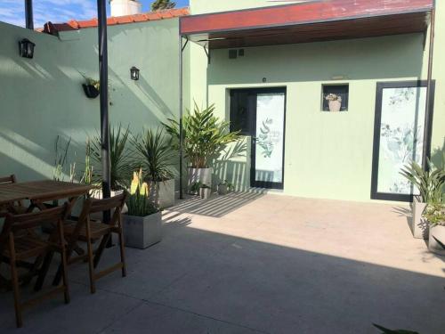 un patio con mesa y sillas y un edificio en Casa moderna y amplia con patio y cochera techada en San Nicolás de los Arroyos