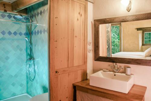 bagno con lavandino, doccia e specchio di Eco lodge Carbonaccio a Chiatra