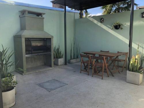 patio al aire libre con mesa y chimenea en Casa moderna y amplia con patio y cochera techada en San Nicolás de los Arroyos