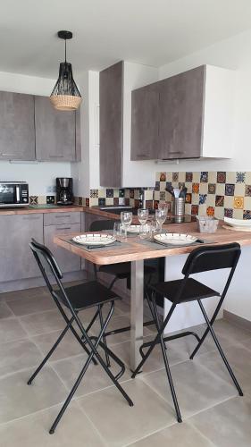 une cuisine avec une table en bois et 2 chaises dans l'établissement T2 NEUF ANGLET CENTRE - BIARRITZ, à Anglet