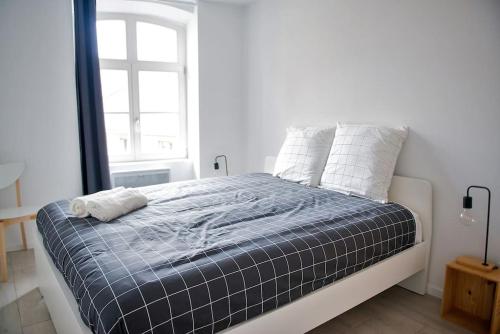 Una cama en una habitación blanca con ventana. en La Pomme Du Président II, en Sélestat