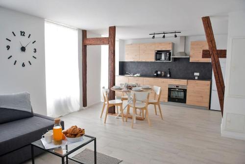 Una sala de estar con un sofá y una mesa con sillas. en La Pomme Du Président II, en Sélestat