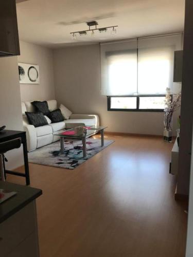 een woonkamer met een witte bank en een tafel bij Apartamento DALÍ in Murcia