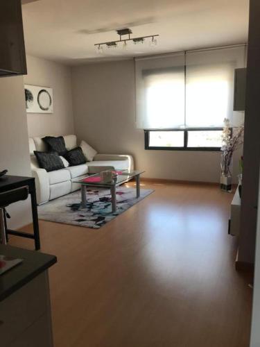 a living room with a white couch and a table at Apartamento DALÍ in Murcia