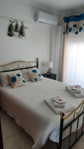 a bedroom with a large white bed with towels on it at Quarteira Beach in Quarteira