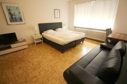 uma sala de estar com uma cama e um sofá em Swiss Star Basel Schweizergasse - Self Check-In em Basileia