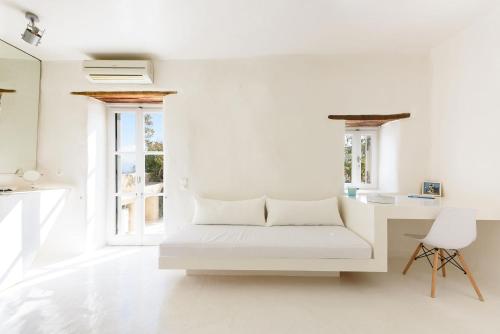 a white room with a bed and a desk at THE OLIVE MILL GUEST HOUSE in Lefkes