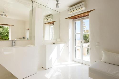THE OLIVE MILL GUEST HOUSE في Lefkes: حمام أبيض مع حوض ومغسلة
