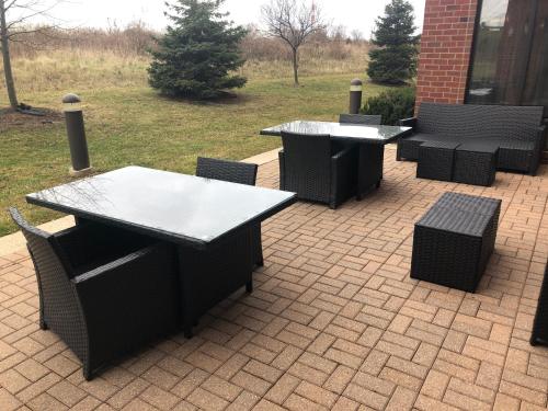 two tables and chairs on a brick patio at Holiday Inn Express Hotel & Suites Lansing-Dimondale by IHG in Dimondale
