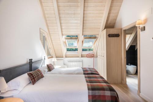 two beds in a small room with two windows at Casa Eth Mur by Totiaran in Naut Aran