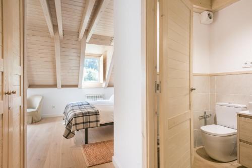 ein Bad mit WC und ein Bett in einem Zimmer in der Unterkunft Casa Eth Mur by Totiaran in Naut Aran