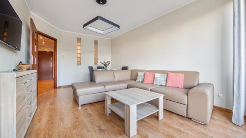 - un salon avec un canapé et une table dans l'établissement Apartamenty Sun & Snow Jasny Brzeg, à Władysławowo
