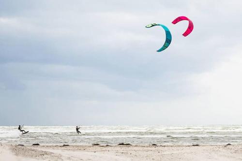 two people are flying a kite on the beach at Skreanäs - Falkenberg in Falkenberg