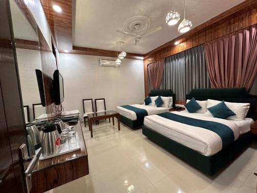 a hotel room with two beds and a flat screen tv at Hotel Baba Deluxe -By RCG Hotels in New Delhi