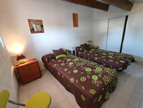 - une chambre avec 2 lits, une table de chevet dans l'établissement ONDINES II Joli T2 mezzanine climatisé Richelieu ONDINES II Cap d'Agde, au Cap d'Agde