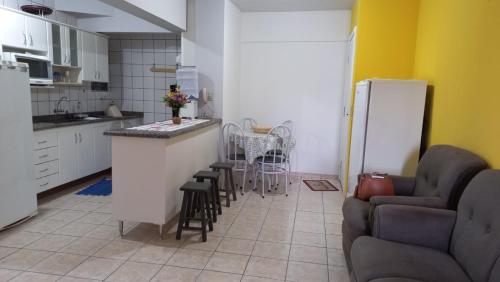 y cocina con encimera, sillas y nevera. en Apto completo no centro 2qtos - Residencial Ponta Verde., en Caldas Novas