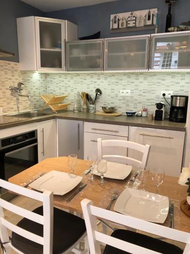 - une cuisine avec une table en bois et des chaises blanches dans l'établissement charmante maison de pêcheur typique, à Trouville-sur-Mer