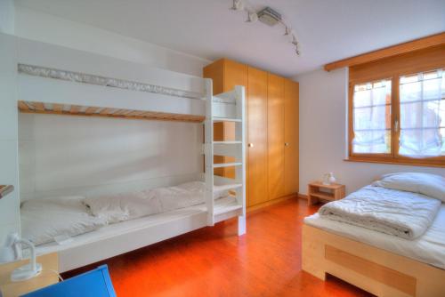 1 Schlafzimmer mit 2 Etagenbetten und einem Fenster in der Unterkunft Aramis 1 in Leukerbad