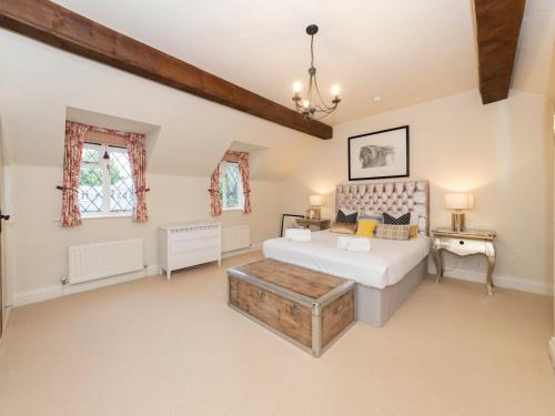 a bedroom with a bed and a table at Pass the Keys Luxurious Country House with Cinema Games Room in Reading