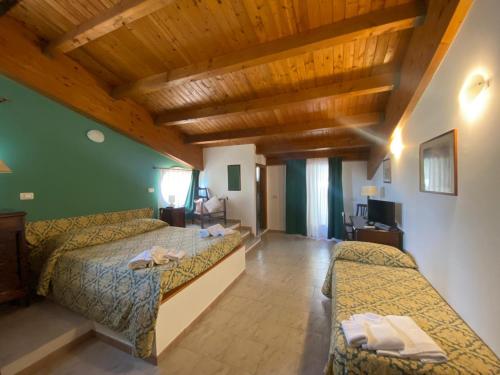1 dormitorio con 2 camas y techo de madera en Fermata Spuligni - Turismo Rurale, en Zafferana Etnea