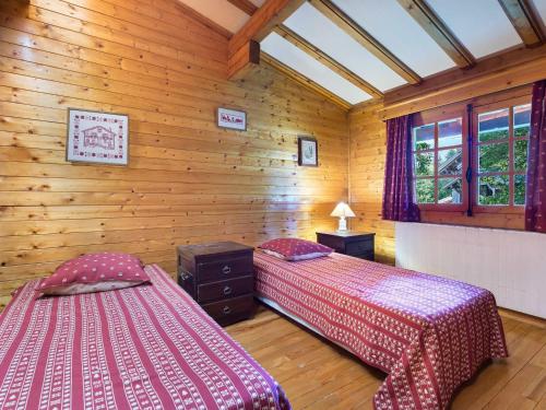 deux lits dans une chambre aux murs en bois dans l'établissement Charmant chalet 2 chambres à Megève Mont d'Arbois, terrasse et jardin, proche des pistes - FR-1-453-255, à Megève
