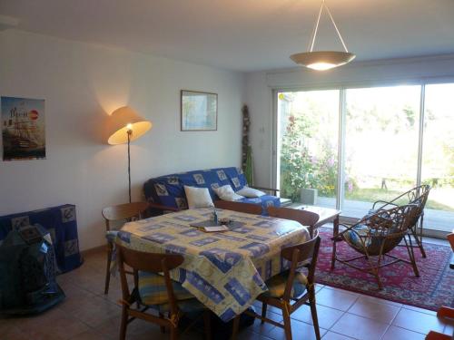 un salon avec une table et un canapé dans l'établissement Maison mitoyenne 3 ch. avec jardin, terrasse et poêle à bois, proche du port de Sauzon, animaux OK - FR-1-418-160, à Sauzon
