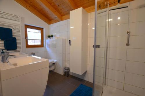 a bathroom with a shower and a sink and a toilet at Feriendorf Via Claudia Haus 62 Bernhard in Lechbruck
