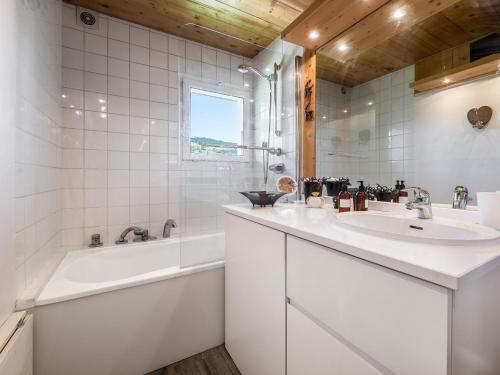 La salle de bains blanche est pourvue de 2 lavabos et d'une baignoire. dans l'établissement Appartement rénové 3 pièces, 6 pers, balcon, proche pistes et commerces, Megève Jaillet - FR-1-453-126, à Megève