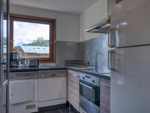 eine Küche mit weißen Geräten und einem Fenster in der Unterkunft Appartement Megève, 3 pièces, 5 personnes - FR-1-453-229 in Megève