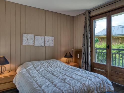 une chambre avec un lit et une grande fenêtre dans l'établissement Charmant 3 pièces à Megève - Balcons, Parking, Wifi, proche télécabine ! - FR-1-453-229, à Megève