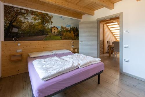 a bedroom with a bed with a painting on the wall at Residenza al Castello in Enguiso