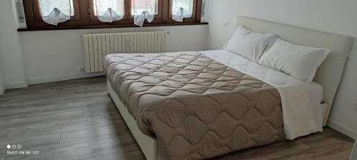 ein Schlafzimmer mit einem großen Bett mit weißer Bettwäsche und Kissen in der Unterkunft Casa vacanza Sant O,rsola in Bergamo