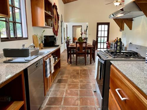 a kitchen with a stove and a dining room at Wanakaset Panama in Dolega